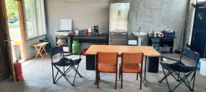 a kitchen with a wooden table and chairs at Secret Garden Camping in Bontida