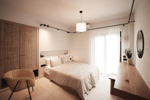 ein weißes Schlafzimmer mit einem Bett und einem Fenster in der Unterkunft Om Living Afitos in Afytos