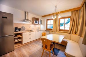 a kitchen with a table and a dining room at Chalet Alpina in Ortisei