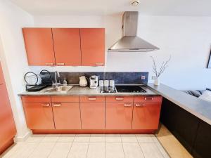 cocina con armarios de color naranja y fregadero en Luxury City Centre Home With Free Secure Parking en Stalybridge