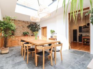 uma sala de jantar com uma mesa de madeira e cadeiras em The Water House em Falmouth