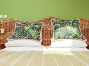 a wicker headboard of a bed with two pillows at The Water House in Falmouth