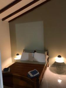 a bedroom with a bed with two lamps on it at UN PLONGEON A la DEMEURE MOCENEA in Richemont