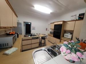 a kitchen with a sink and a counter with flowers at Zenith House Boston Self Catering Accomodation in Cape Town
