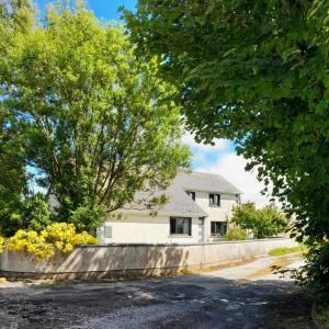 una casa blanca con una valla y un árbol en Finner House, en Ballyshannon