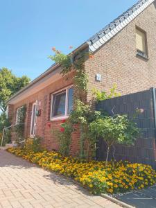 a brick house with flowers in front of it at Helle Ferienwohnung in Nettetal bei Venlo in Nettetal