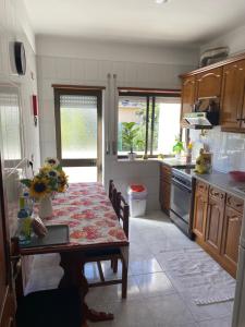 a kitchen with a table with flowers on it at Azul sea’s view flat (3bedrooms), 3 terraces/wifi in Buarcos +21 photos