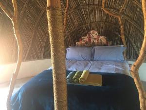 a bed in a room with a wicker head board at Swazi Dreams. (Nqabaneni Eco-Volunteering.) in Usutu