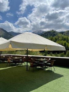 a group of tables and chairs under a large umbrella at Samal Resort & SPA in Almaty