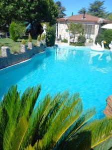 a large swimming pool with blue water in a yard at Casa Solis Monteprincipe in Boadilla del Monte