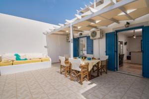 a patio with a table and chairs and a couch at Vira Vivere Houses in Plaka Milou