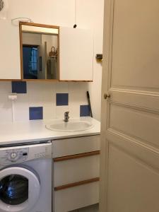 a bathroom with a washing machine and a sink at Les Platanes - Gaugain in Lamalou-les-Bains