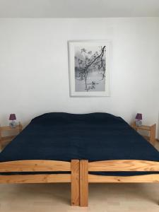 a bed with a blue blanket on it in a bedroom at Les Platanes - Gaugain in Lamalou-les-Bains