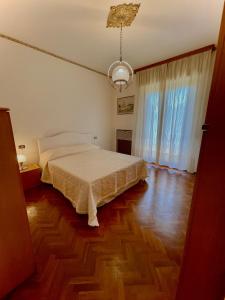 a bedroom with a bed and a wooden floor at Angela Home in Rimini