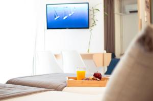ein Tablett mit Essen und ein Glas Orangensaft auf dem Bett in der Unterkunft Acropol Hotel in Athen