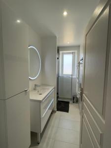 uma casa de banho branca com um lavatório e um espelho em Maison 80m2 entièrement rénovée à 1,5km de la plage des Conches em Longeville-sur-Mer