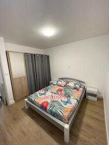 um quarto com uma cama com um edredão colorido em Maison 80m2 entièrement rénovée à 1,5km de la plage des Conches em Longeville-sur-Mer