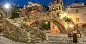 un grupo de personas de pie junto a un puente de piedra en Casa Pepito en Bogliasco