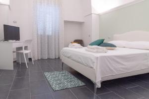 Dormitorio con cama, escritorio y TV en Il vecchio arco en Novoli