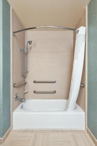 a bathtub in a bathroom with a shower curtain at Holiday Inn Express & Suites Eureka, an IHG Hotel in Eureka