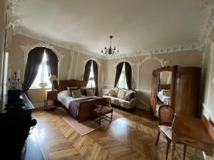 - une chambre avec un lit, un canapé et des fenêtres dans l'établissement Manoir Sainte Cecile Art Nouveau, à Juvigny-sous-Andaine