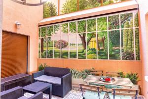 patio ze stołem i krzesłami oraz oknem w obiekcie Casa Juturne 22, proximité Monaco w mieście Beausoleil