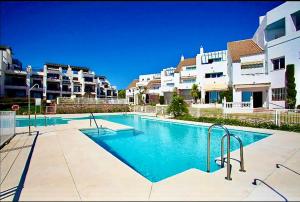 a swimming pool in front of some apartment buildings at My Space on the Beach, Luxury Apartment in Casares