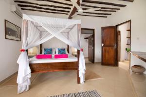 a bedroom with a bed with a canopy at Matemwe Rock Villas in Matemwe