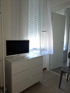 uma televisão numa cómoda num quarto com uma janela em Hotel Marco em Lido di Savio