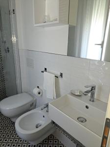 Hotel Marco في ليدو دي سافيو: حمام ابيض مع مرحاض ومغسلة