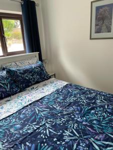 a bedroom with a bed with blue sheets and a window at Studio Annie in Findon