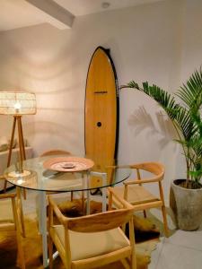 ein Esszimmer mit einem Glastisch und einem Surfbrett in der Unterkunft Seminyak Beach Tropical Hideaway Apartment in Seminyak