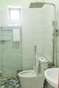 コンダオにあるSUNRISE HOTELの白いバスルーム(トイレ、シンク付)