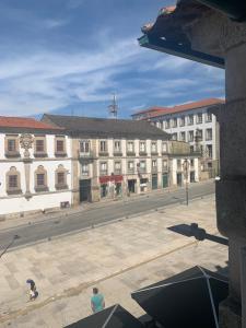 dos personas están caminando en una calle de la ciudad con edificios en Residencial Encontro en Vila Real