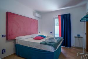 een slaapkamer met een bed met een groot rood hoofdeinde bij Villa Luce in Itri