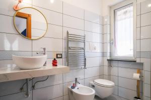 een badkamer met een wastafel, een toilet en een spiegel bij Villa Luce in Itri