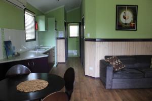 sala de estar con sofá y mesa en Big4 Aussie Outback Oasis Holiday Park, en Charters Towers