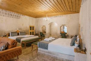 Lunar Cappadocia Hotel في غوريمِ: غرفة نوم بسريرين واريكة