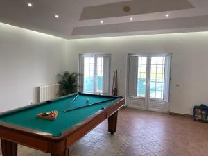 Una mesa de billar en una sala de estar con billar. en Quinta dos Filipes, en Palmela