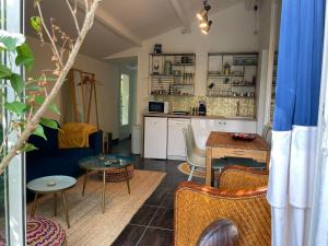 ein Wohnzimmer mit einem Sofa und einem Tisch in der Unterkunft Maison dans sa Jungle, aux milliers d’espèces… in Montmagny