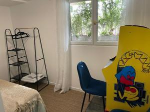 Zimmer mit einem Stuhl, einem Bett und einem Fenster in der Unterkunft Maison dans sa Jungle, aux milliers d’espèces… in Montmagny