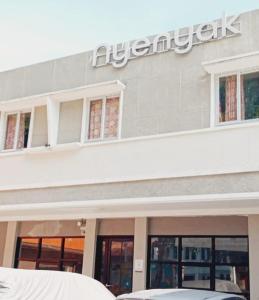 a sign on the side of a building with cars parked outside at Nyenyak Senayan Benhil in Jakarta