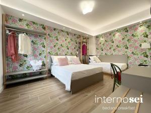ein Schlafzimmer mit zwei Betten und Blumentapete in der Unterkunft Interno Sei B&B in Agropoli