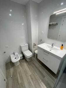 a white bathroom with a toilet and a sink at Playa Marbella in Marbella