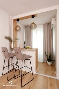 una cocina con 2 sillas y una mesa en una habitación en Brand new lovely studio close to Favorit metro station, en Bucarest