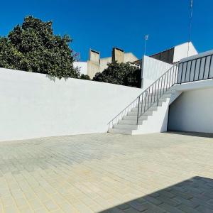 a white wall with a staircase next to a stair case at Casa do Carmo in Sousel