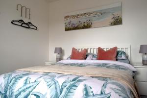 una camera da letto con un letto con cuscini colorati di The Old Fishermans Lookout a Falmouth
