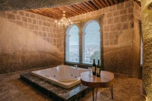 a bathroom with a tub and a table with wine bottles at Lunar Cappadocia Hotel in Goreme