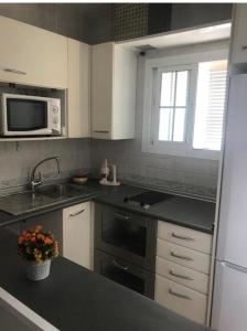 a kitchen with a sink and a microwave at Mar Marina in Benalmádena