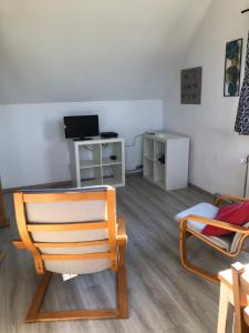 sala de estar con silla y TV en Appartement lumineux et calme en Jodoigne